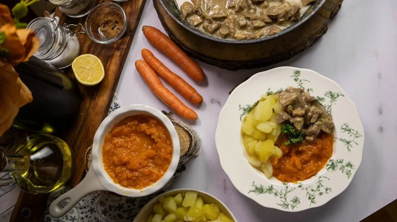 Připravené mrkvové jídlo s masem a bramborami na talíři.