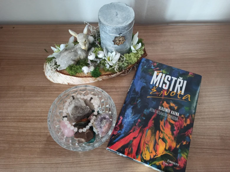 Kniha Vladimíra Kafky Mistři života s krystaly na stole.
