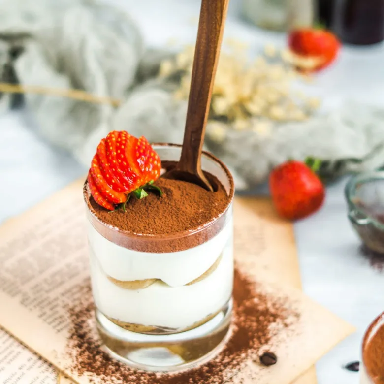 Hotový zdravý tiramisu v skleničce s jahodou.