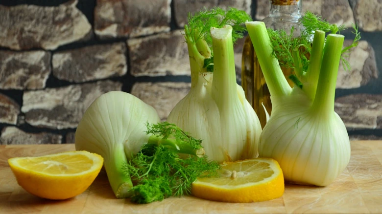 Čerstvý fenikel s citronem na dřevěném prknu.