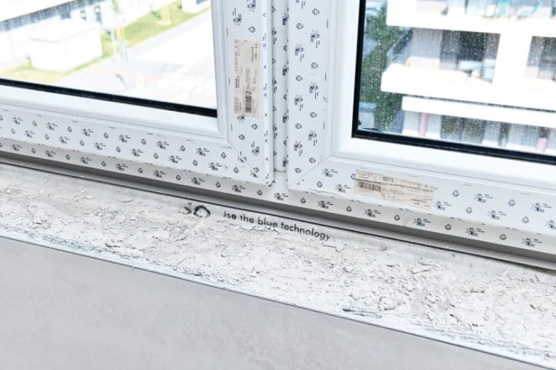 Detail parapetu okna s ochrannou fólií v průběhu stavby.