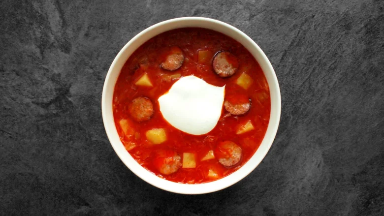 Red soup with sausage and sour cream