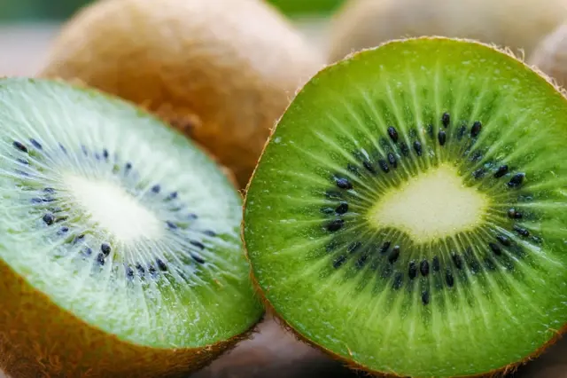Sličný kousek zeleného kiwi s černými semínky