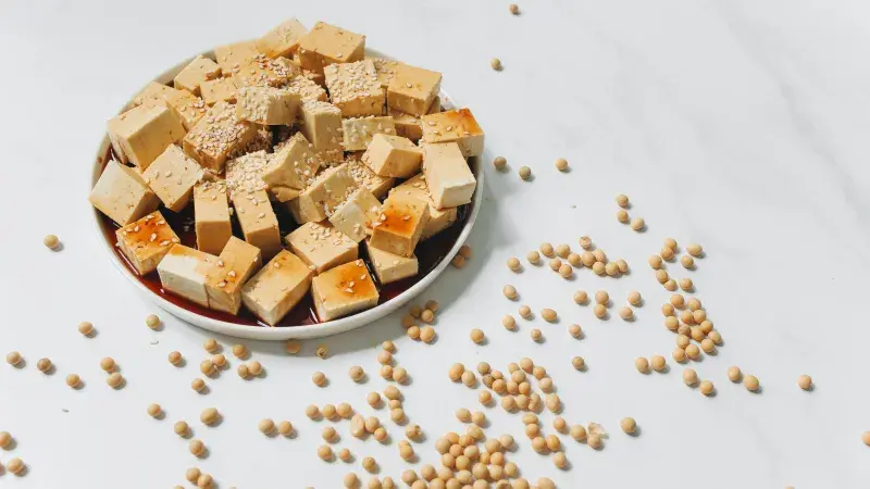 Marinované tofu kostky s sezamem na bílém podkladu.