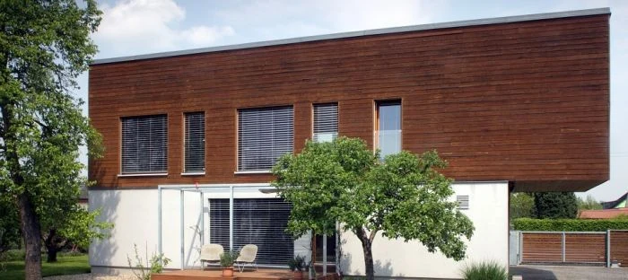 Moderní dvoupodlažní dřevořezaná stavba s velkými okny