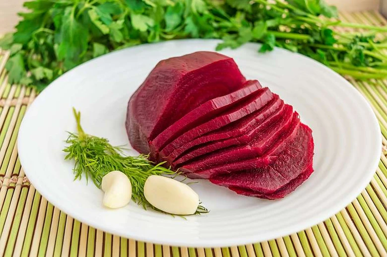 Slicovaná červená řepa na talíři s bylinkami