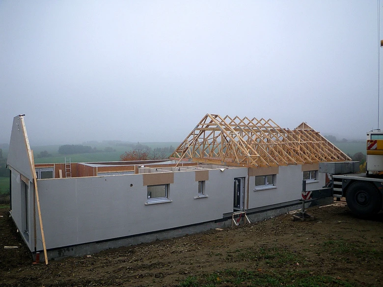 Dřevostavba v stavbě s viditelnou konstrukcí střechy.
