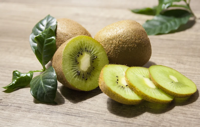 Zelené kiwi plody na dřevěném podkladu