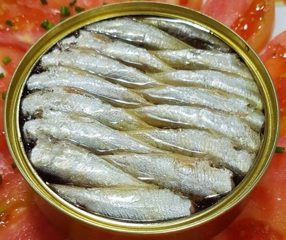Otevřená plechovka se solenými sardinami v oleji.