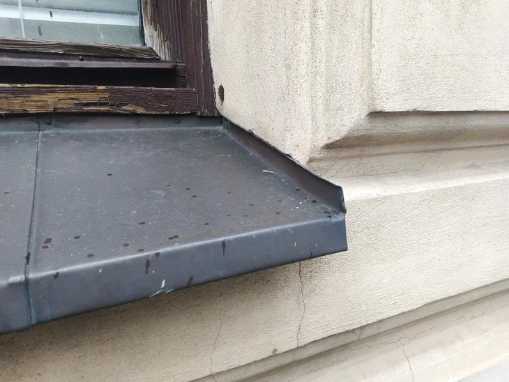Detail parapetu s ocelovou lištou u okna