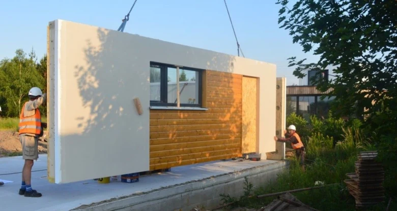 Práce na stavbě bungalovu s montáží prefabrikovaných panelů.