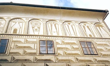Detail fasády budovy s výzdobou technikou sgrafita.