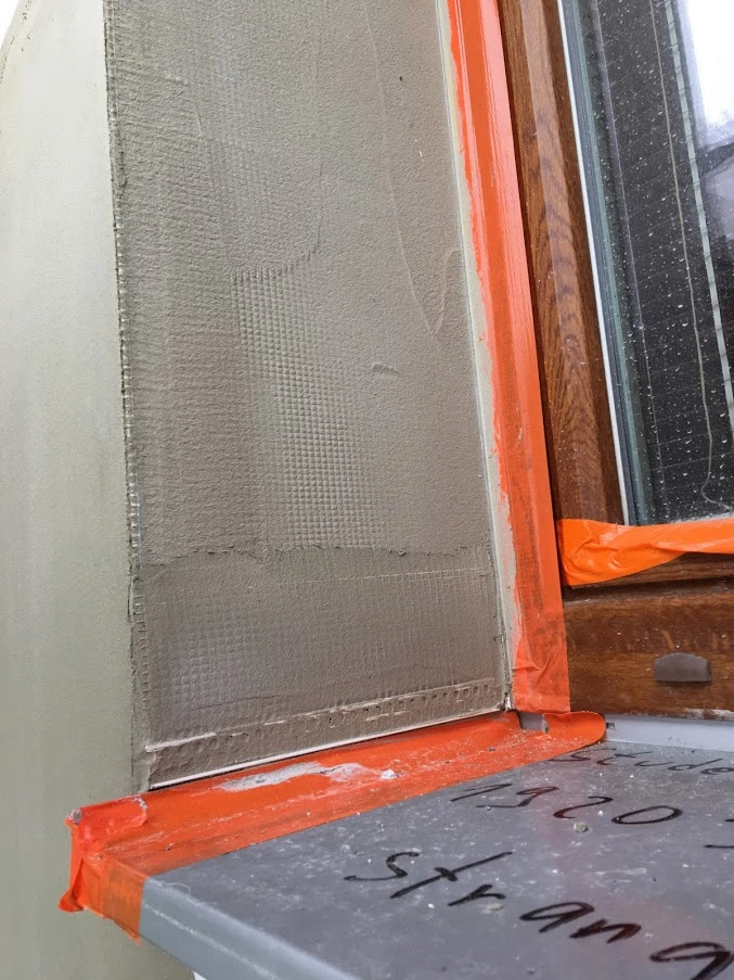 Detail parapetu s mřížkou před omítkou u okna