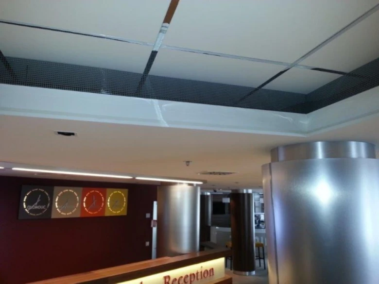 Akustické podhledy v kanceláři s moderním designem a osvětlením.