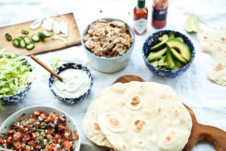 Suroviny na domácí tacos: maso, avokádo, salát, salsu a tortilly.