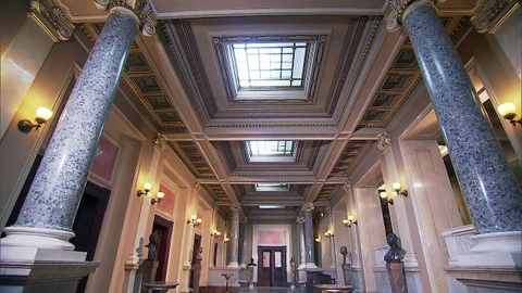 Velkolepý foyer s mramorovými sloupy a zdobeným stropem.